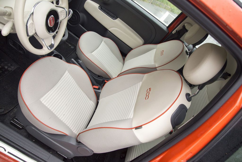 Fiat 500 im Innenraum. Helle Sitze mit orangem 500 Schriftzug.